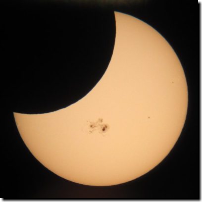 [Partial solar eclipse, with sunspots]