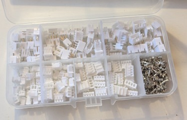 [a box with compartments for several sizes of small white connectors, plus one compartment filled with little metal pieces]