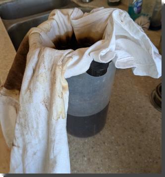 [a shirt that appears to be tie-dyed, but only in brown dye, is draped over a plasticpitcher to be used as a filter for making coffee. There's a coffee filter holder in the top of the pitcher, and the shirt is inside that where normally a paper filter would go]