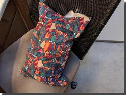 [a small pillow of a colorful patterned canvas, with one corner still open and a little of the stuffing visible]